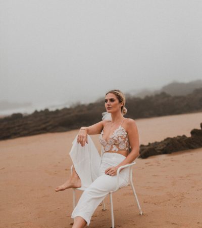 Deutsch: Vogue-Moment: Modische Braut sitzt auf Stuhl am Strand Englisch: Vogue-moment: Fashionable bride seated on chair at the beach